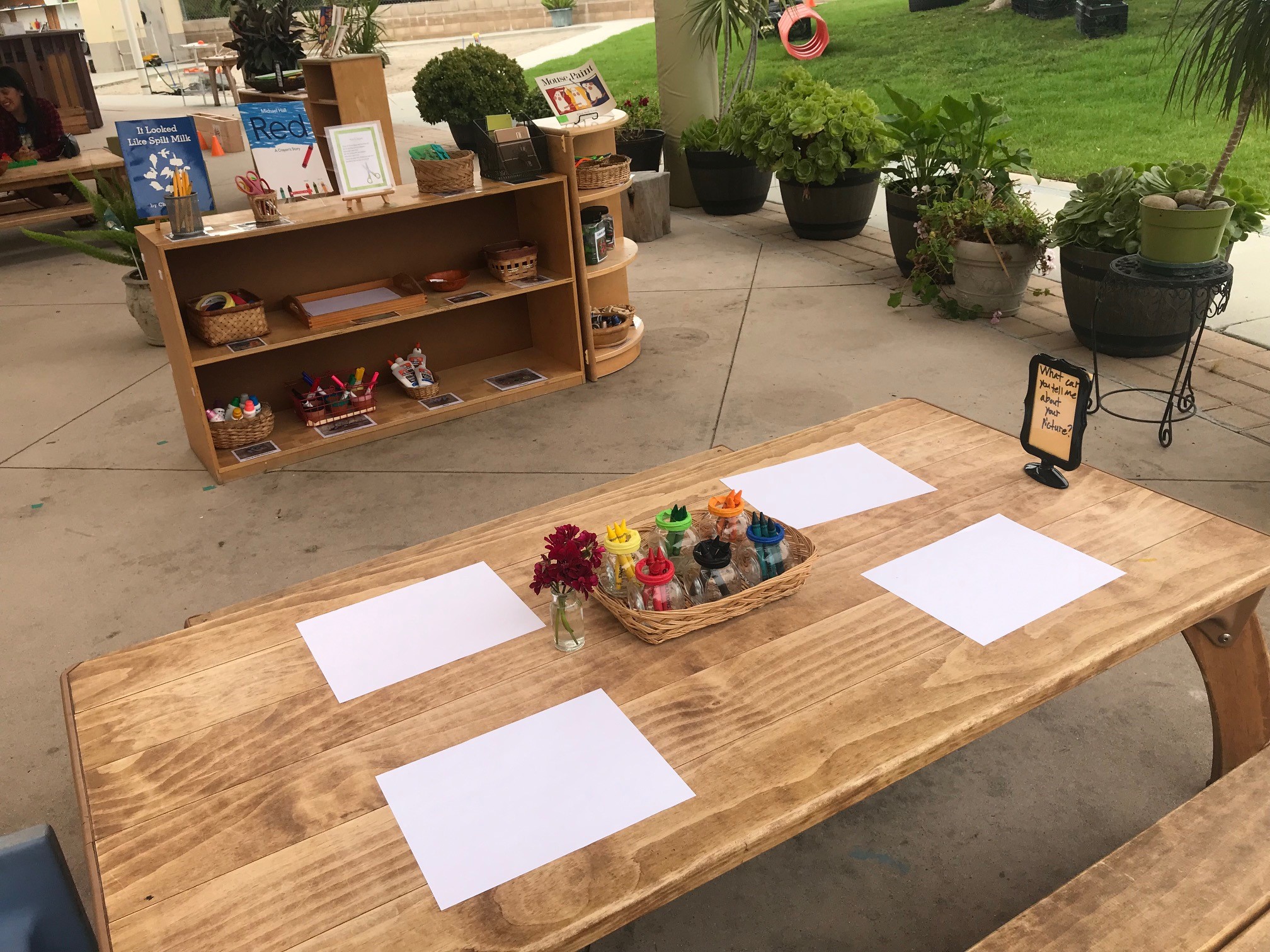 picture of outdoor art table with crayons and paper